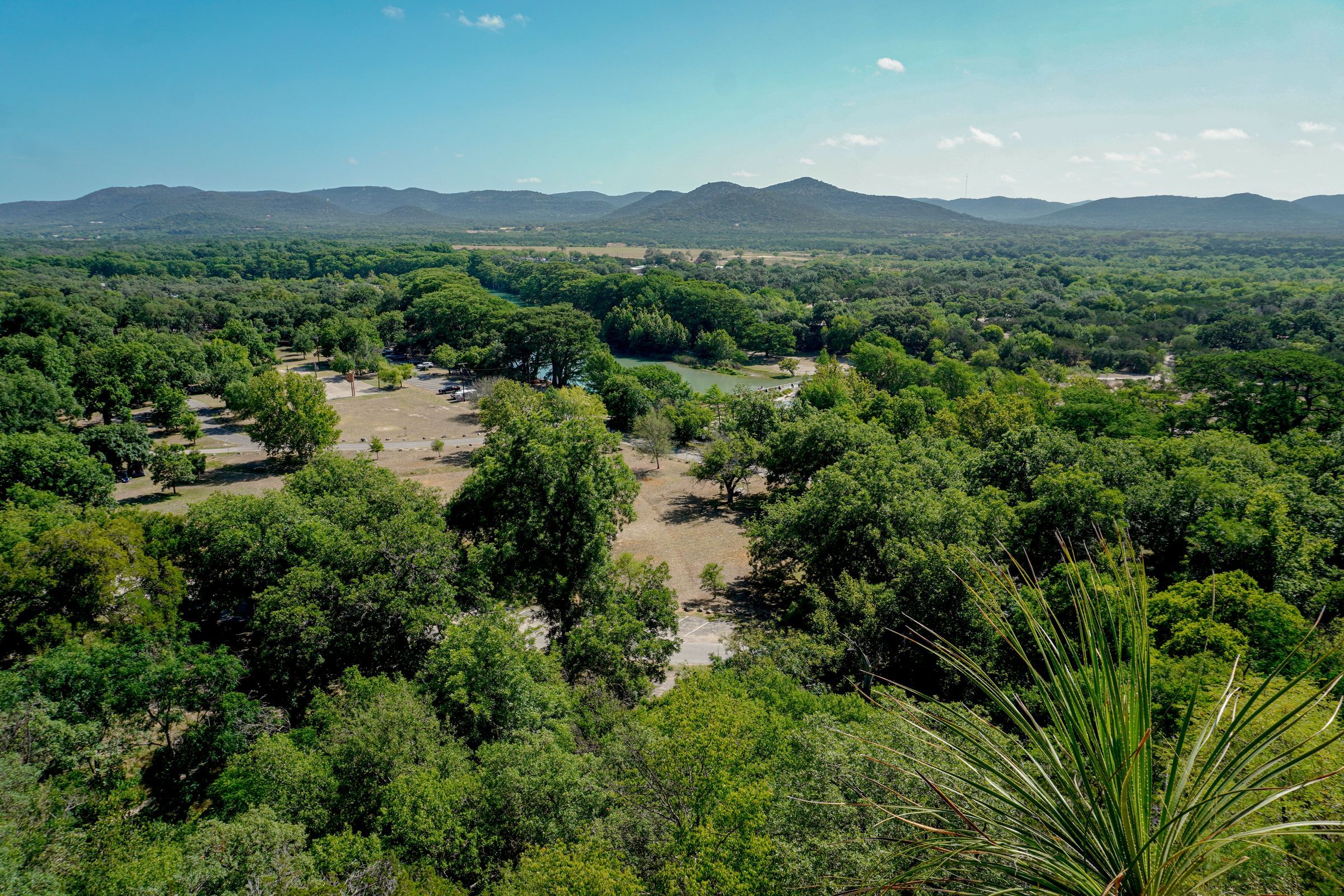 Wooded valley and low hills under a clear sky in the Texas Hill Country